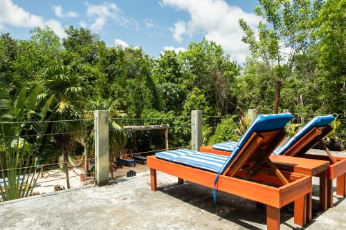 a pair of lounge chairs sitting on a patio at Hokhmah Heart Hotel in Puerto Morelos