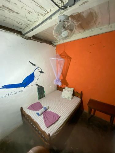 a small bed in a room with a painting on the wall at Eco lodge finca magdalena in Altagracia
