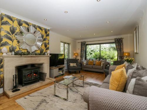 a living room with a fireplace and a tv at Bell Garden in Stow on the Wold