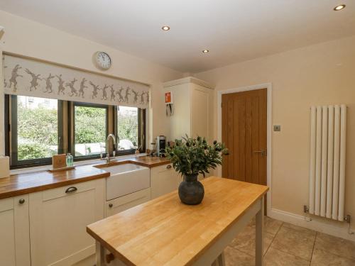 a kitchen with a vase of flowers on a table at Bell Garden in Stow on the Wold