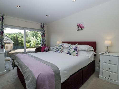 a bedroom with a large bed and a large window at Bell Garden in Stow on the Wold
