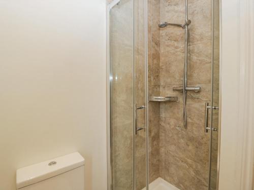 a shower with a glass door in a bathroom at Bell Garden in Stow on the Wold