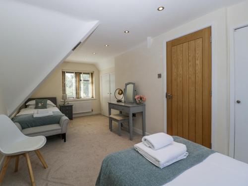 a bedroom with two beds and a desk and a staircase at Bell Garden in Stow on the Wold