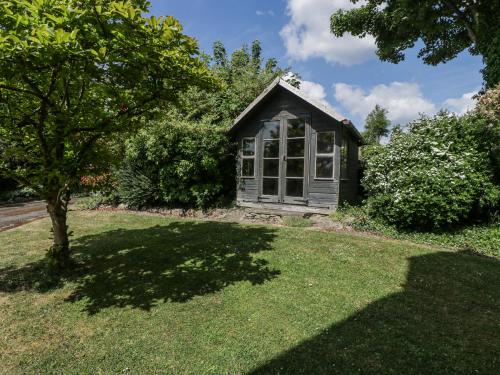 a small house in a yard with a tree at Bell Garden in Stow on the Wold