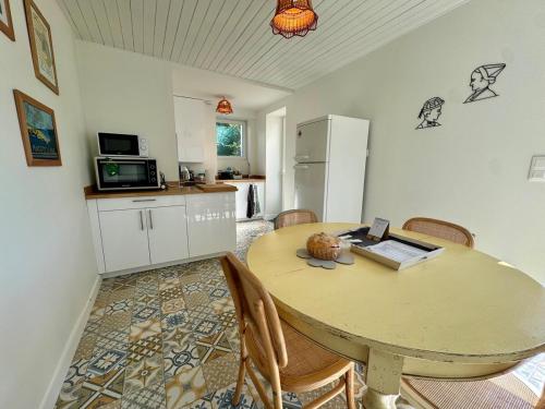 - une cuisine avec une table et un ordinateur portable dans l'établissement Maison pleine de charme entre terre et mer, à Le Poiré-sur-Vie