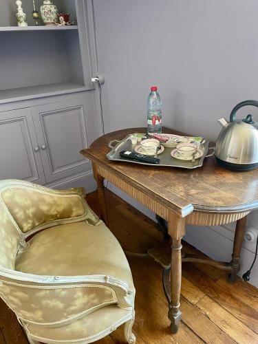 a table with a tea kettle and a table with a chair at Les chambres du Chateau de Farge-Allichamps in Farges-Allichamps