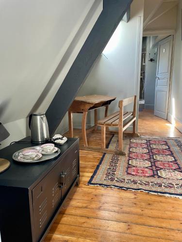 a living room with a table and a stairway at Les chambres du Chateau de Farge-Allichamps in Farges-Allichamps