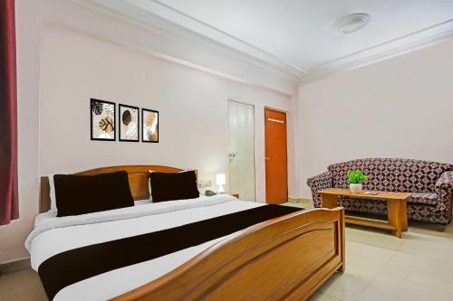 a bedroom with a large bed and a couch at Super Hotel O Bhagalpur Railway Junction in Bhāgalpur