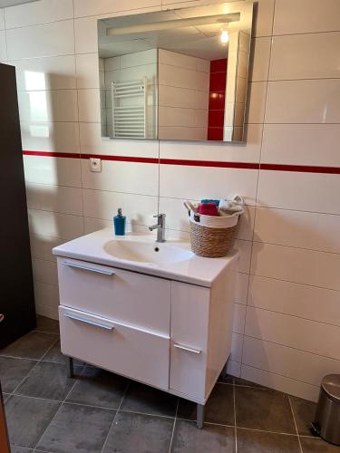 une salle de bain avec un lavabo blanc et un miroir dans l'établissement Hébergement Ostwald, à Ostwald