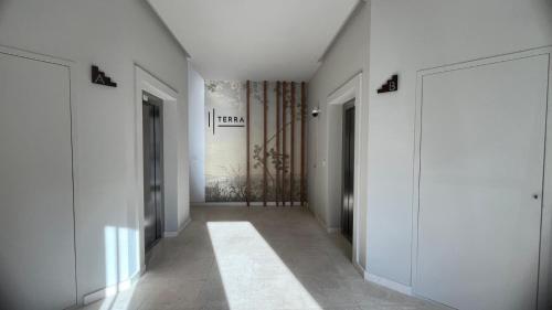 a hallway with white walls and a hallway with doors at Valesium Home in Lecce