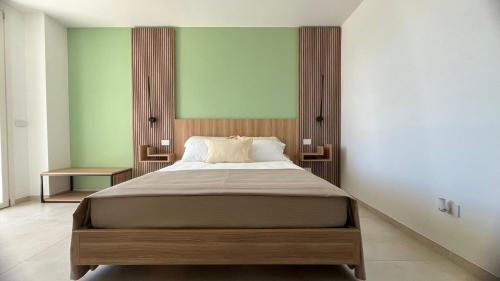 a bedroom with a large bed and a green wall at Valesium Home in Lecce