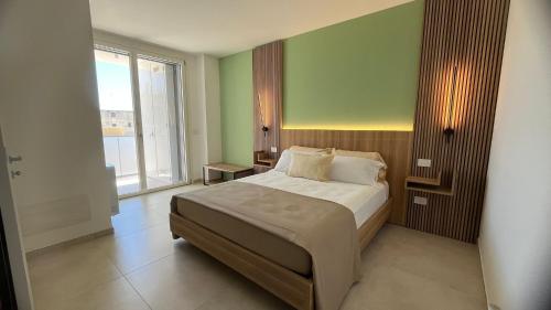 a bedroom with a bed and a large window at Valesium Home in Lecce