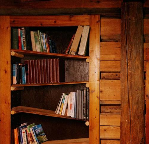 a book shelf full of books in a cabin at Rustic Beaverfoot Lodge Room N3 in Parson