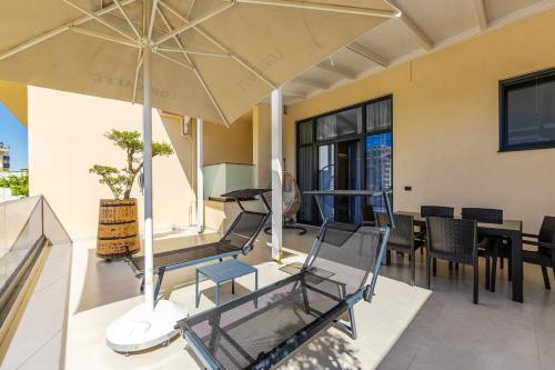 a patio with a table and chairs and an umbrella at Emily Jacuzzi Veranda by PS in Durrës