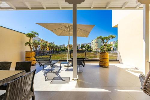 a patio with a table and chairs and an umbrella at Emily Jacuzzi Veranda by PS in Durrës