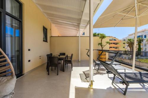 a balcony with a table and chairs and an umbrella at Emily Jacuzzi Veranda by PS in Durrës