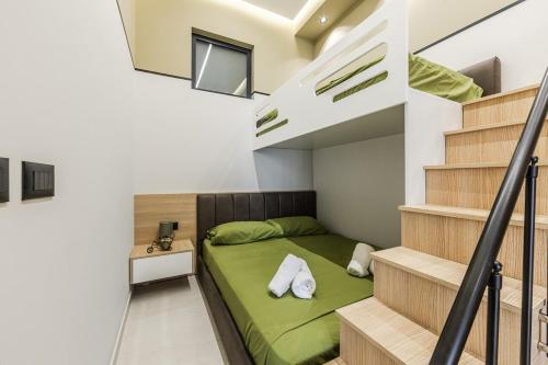 a small bedroom with a green bed and stairs at Emily Jacuzzi Veranda by PS in Durrës