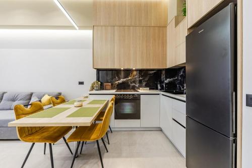 a kitchen with a table and a black refrigerator at Emily Jacuzzi Veranda by PS in Durrës