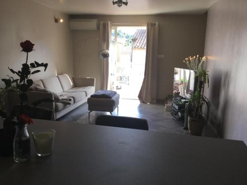 un salon avec un canapé blanc et une table dans l'établissement Maison de village à 2 min des calanques, à Ensuès-la-Redonne