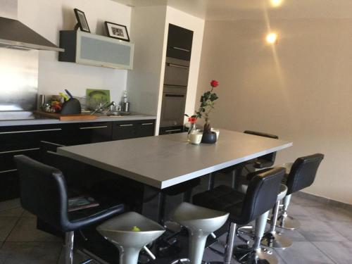 une cuisine avec une table et des chaises dans l'établissement Maison de village à 2 min des calanques, à Ensuès-la-Redonne
