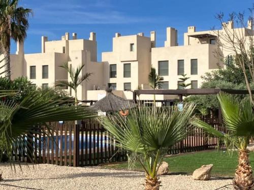 a large white building with palm trees in front of it at Casa Alegria Penthouse in Corvera