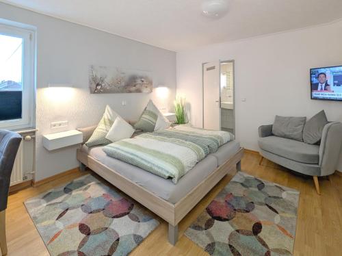 a bedroom with a bed and a couch and a chair at Hotel Maurer in Saarwellingen