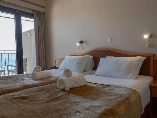 a bedroom with two beds with towels on them at Sappho Hotel in Skala Eresou