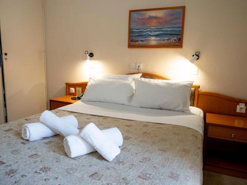 a bedroom with a large bed with white pillows at Sappho Hotel in Skala Eresou