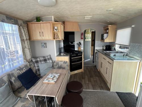 a small kitchen with a table and a couch in it at Holiday Caravan in Clacton-on-Sea