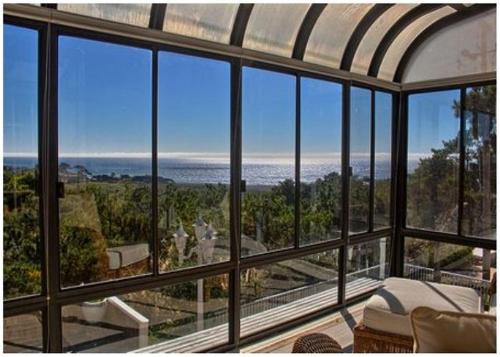 a room with a view of the ocean through windows at Casa Coventry in Cambria