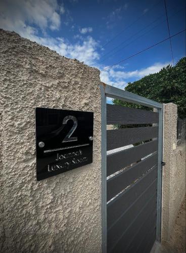 a sign on the side of a building next to a gate at Joannas Airport Luxury Rooms in Artemida