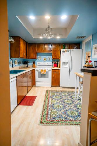 a kitchen with white appliances and a rug at Bohemian Bungalow in Port Saint Lucie