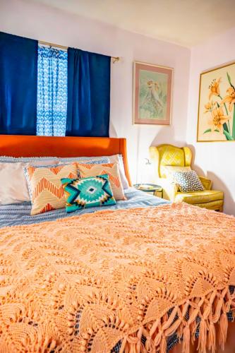 a bedroom with a large bed with blue curtains at Bohemian Bungalow in Port Saint Lucie