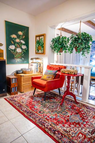 a living room with a red couch and a table at Bohemian Bungalow in Port Saint Lucie