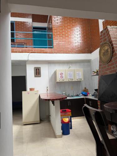 a kitchen with a table and a refrigerator at Hospedaje del Cafe Salento in Salento