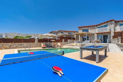 a swimming pool with a ping pong table and a pool at Villa Chloe Seastone by Villa Plus in Kiotari