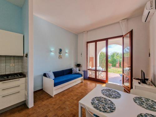 a living room with a blue couch and a kitchen at Casa Golfi di Lacona in Lacona