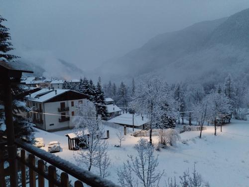 een dorp bedekt met sneeuw met bergen op de achtergrond bij Castori 1 in Prazzo