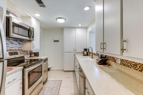 a large kitchen with white cabinets and appliances at Pool and Trail Access On-Site Barton Creek Condo! in Austin