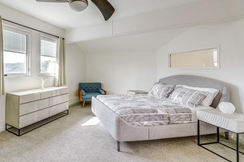a white bedroom with a bed and a blue chair at Pool and Trail Access On-Site Barton Creek Condo! in Austin