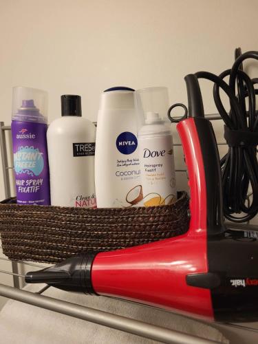 a red scissors and other cleaning products on a shelf at Cozy Suite with HOT TUB & Highspeed Internet in Grimsby
