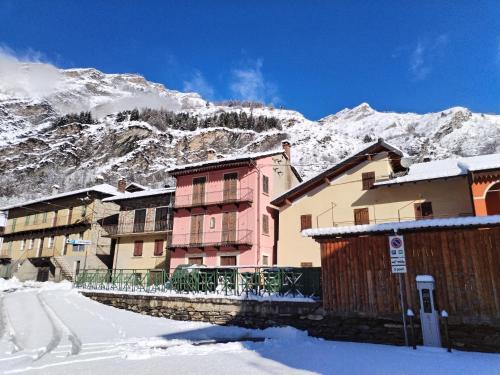 een groep gebouwen in de sneeuw naast een berg bij Castori 1 in Prazzo