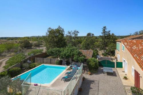 une piscine dans une cour à côté d'une maison dans l'établissement Villa Caroline by Villa Plus, à Thèzan-lès-Béziers