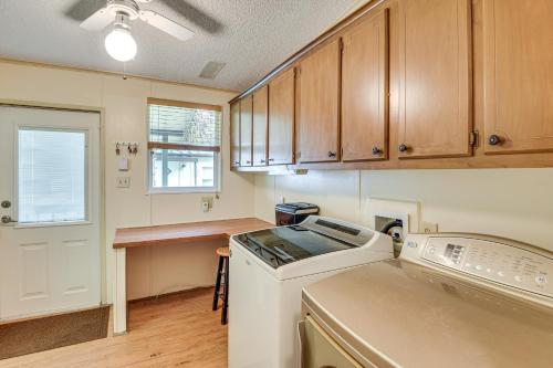 a kitchen with wooden cabinets and a washer and dryer at Boat Dock and Waterfront Deck Home in Satsuma! in Satsuma