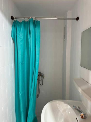 a bathroom with a blue shower curtain next to a sink at BIG Grandalla by CONFORTSKY in Pas de la Casa