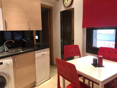 a kitchen with a white table and red chairs at Sky 101 by Confortsky in Pas de la Casa