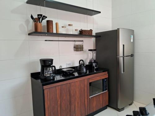 a kitchen with a stove and a refrigerator at Lindo apto de 2 quartos e 1 banheiro c/ garagem in São Roque