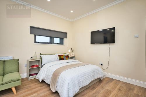 a bedroom with a bed and a tv on the wall at Stratford, London E15 - modern Studio for 3 in London