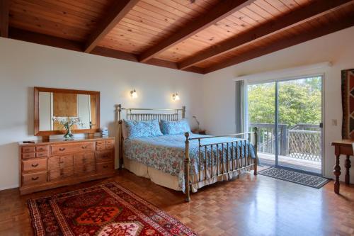 a bedroom with a bed and a mirror and a window at A Cool House, A Cool View in Cambria