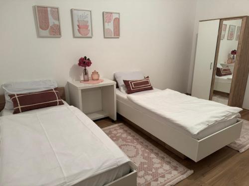 two beds in a room with a mirror at Apartman Centar in Posušje